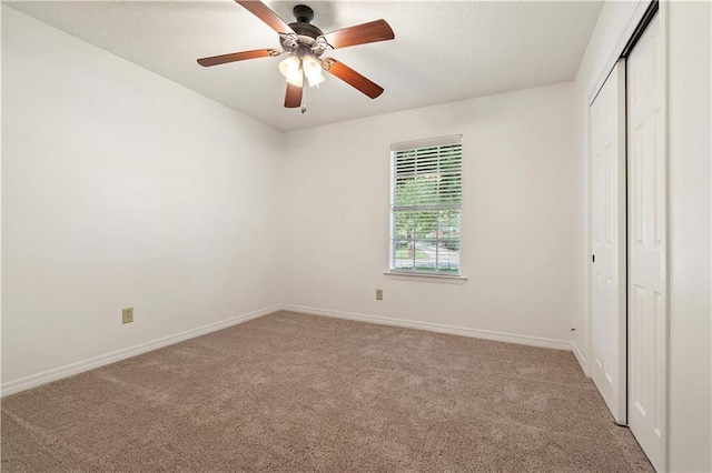 unfurnished bedroom featuring carpet, ceiling fan, and a closet