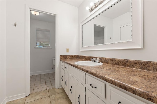 bathroom with tile patterned flooring, vanity, and toilet