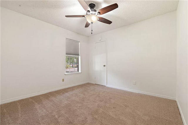 carpeted empty room featuring a textured ceiling and ceiling fan