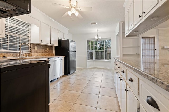 kitchen featuring light tile patterned flooring, black refrigerator, pendant lighting, dishwasher, and white cabinets