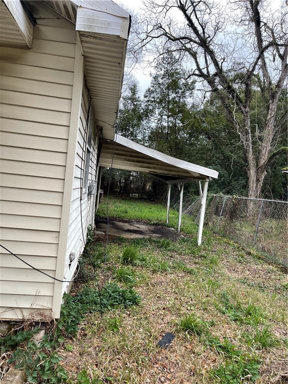 view of yard featuring a carport and fence