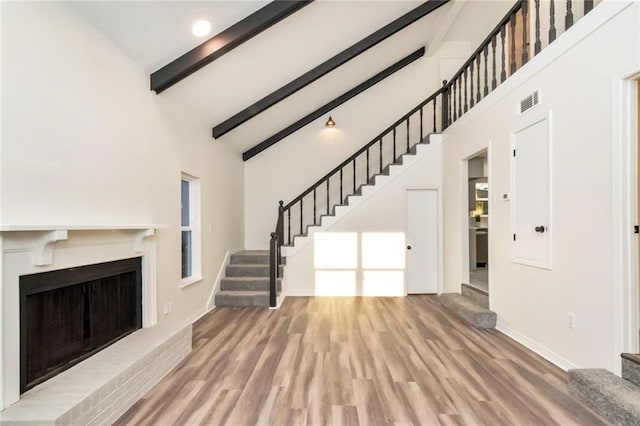 9636 Hamilton Creek Dr S, Mobile, AL 36695 - unfurnished living room with stairs, high vaulted ceiling, wood finished floors, beam ceiling, and a fireplace