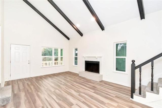 9636 Hamilton Creek Dr S, Mobile, AL 36695 - unfurnished living room with beamed ceiling, wood finished floors, stairs, a fireplace with raised hearth, and high vaulted ceiling