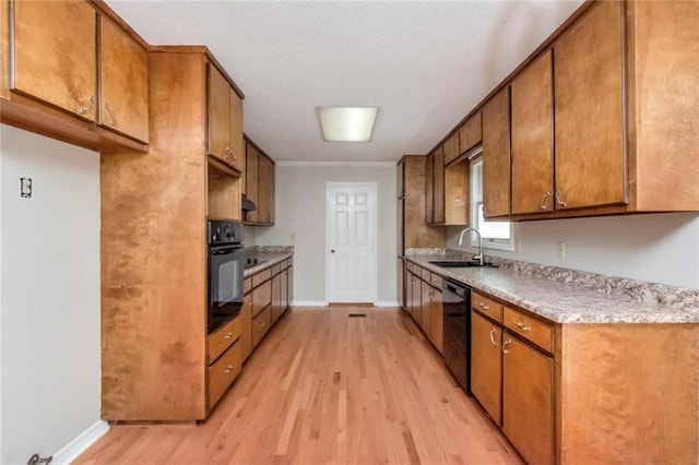 kitchen featuring sink, black appliances, ornamental molding, and light wood-type flooring