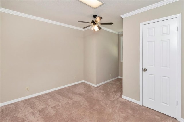 spare room featuring carpet, ornamental molding, and ceiling fan