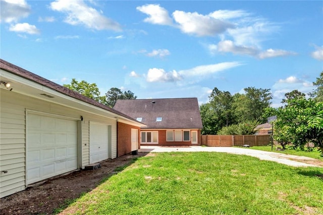 back of house with a yard and a garage