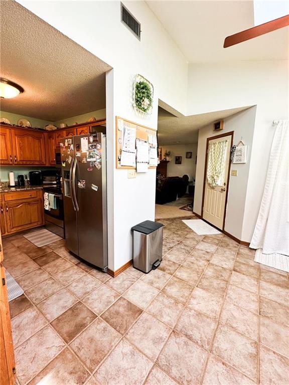 kitchen with vaulted ceiling, stainless steel appliances, and a textured ceiling