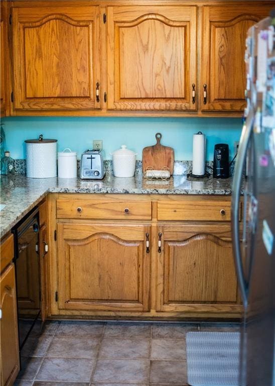 kitchen featuring stainless steel fridge and light stone countertops