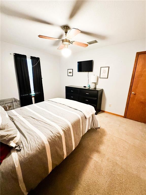 bedroom featuring ceiling fan and light carpet