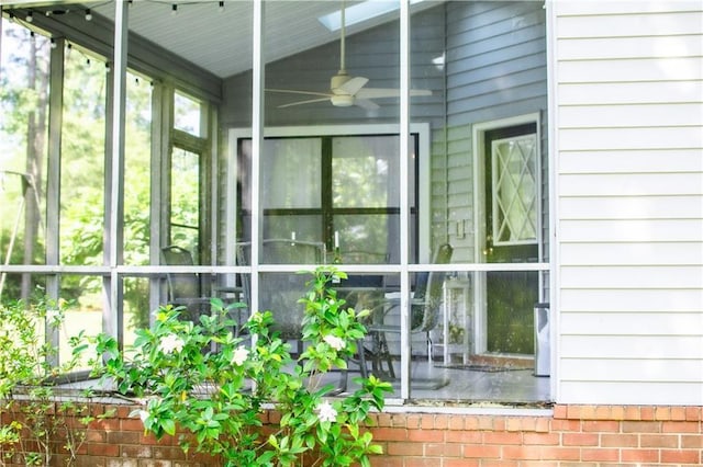 unfurnished sunroom featuring lofted ceiling and ceiling fan