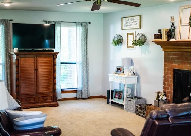 living area with a brick fireplace, carpet, and ceiling fan