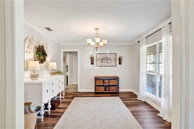 living area with dark wood-style floors, visible vents, a textured ceiling, crown molding, and a notable chandelier