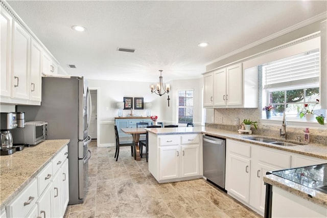 kitchen with visible vents, a peninsula, a sink, white cabinets, and appliances with stainless steel finishes