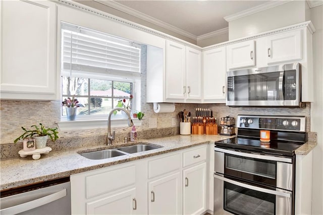 kitchen with ornamental molding, a sink, appliances with stainless steel finishes, white cabinetry, and tasteful backsplash