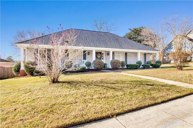 ranch-style house featuring a front yard, covered porch, and roof with shingles