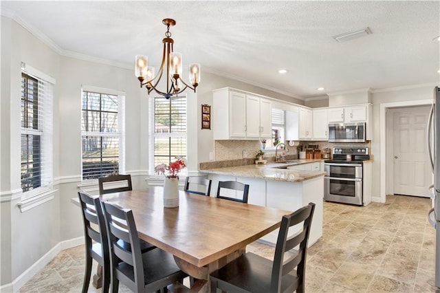 dining space featuring visible vents, an inviting chandelier, baseboards, and ornamental molding