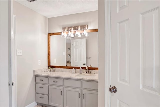 bathroom with a textured ceiling and vanity