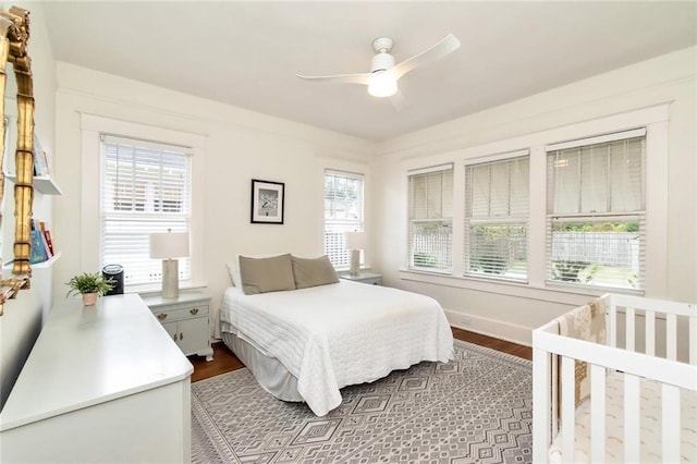 bedroom featuring ceiling fan, baseboards, and dark wood finished floors