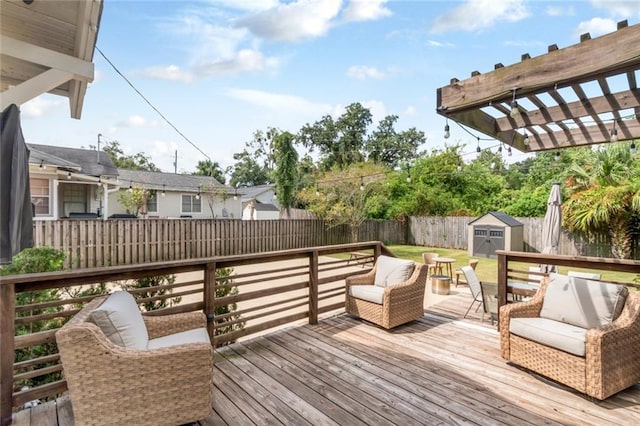 deck with a pergola, an outdoor hangout area, a fenced backyard, an outbuilding, and a storage unit