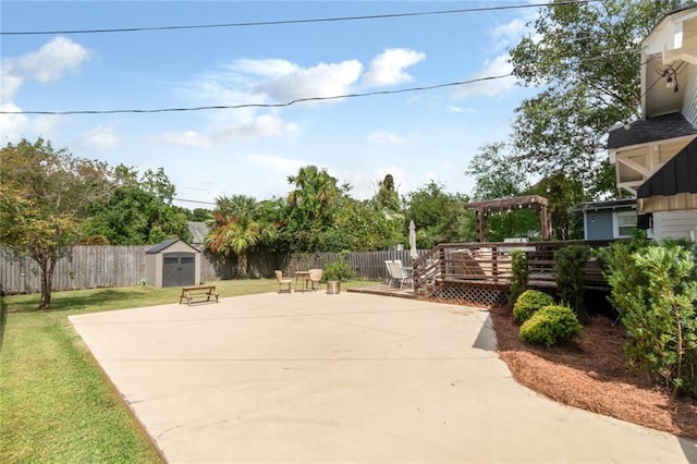 view of patio / terrace with a fenced backyard, a deck, a storage shed, and an outdoor structure