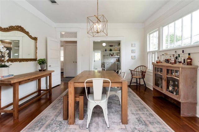 dining space featuring a notable chandelier, dark wood-type flooring, and visible vents