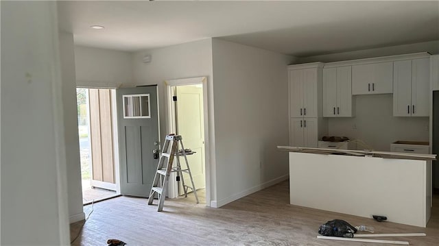 kitchen featuring white cabinetry, a kitchen island, and light wood-type flooring