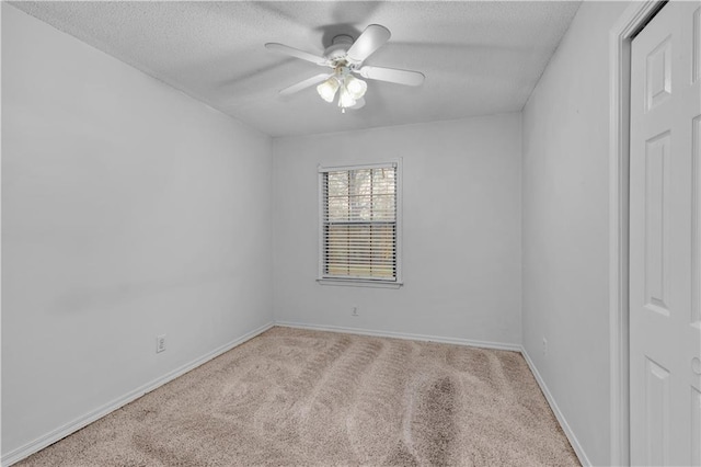 spare room featuring ceiling fan, a textured ceiling, and light carpet