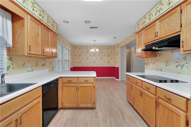 kitchen featuring hanging light fixtures, light hardwood / wood-style floors, a chandelier, and black appliances