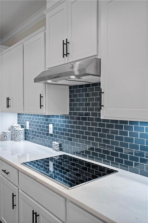 kitchen featuring ornamental molding, black electric stovetop, decorative backsplash, and white cabinets