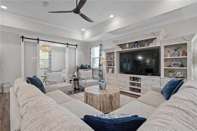 living room featuring crown molding, hardwood / wood-style flooring, a barn door, and ceiling fan