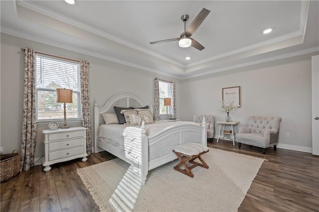 bedroom featuring dark hardwood / wood-style flooring, a tray ceiling, and crown molding