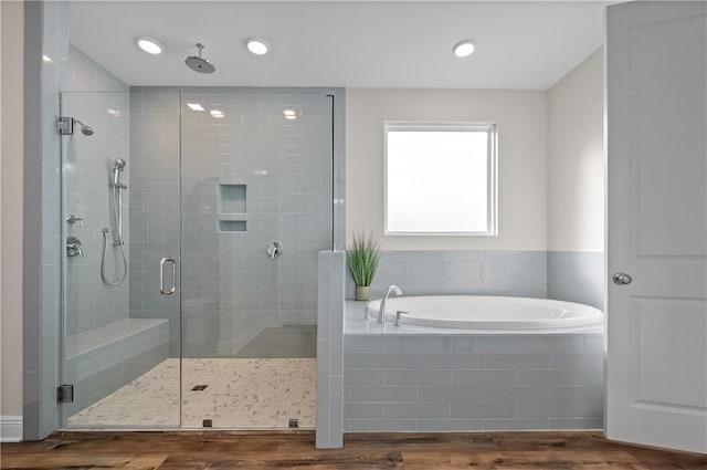 bathroom featuring wood-type flooring and separate shower and tub