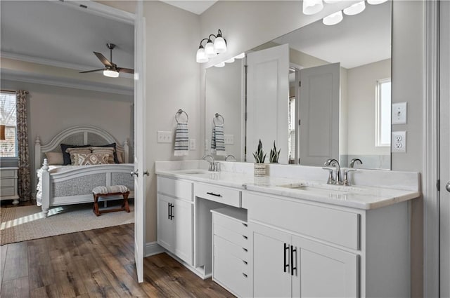 bathroom with vanity, crown molding, wood-type flooring, and ceiling fan