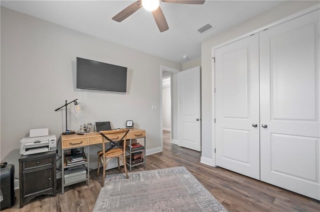 home office with dark hardwood / wood-style floors and ceiling fan