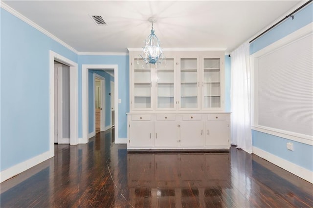 208 Beck St, Atmore, AL 36502 - unfurnished dining area featuring dark wood finished floors, a chandelier, and crown molding