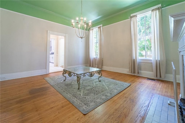 1703 Dauphin St, Mobile, AL 36604 - dining room featuring a chandelier, plenty of natural light, wood finished floors, crown molding, and baseboards