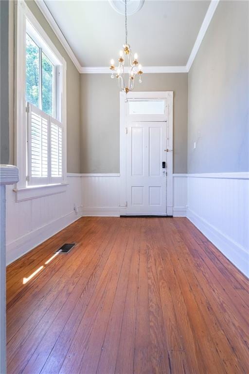 1703 Dauphin St, Mobile, AL 36604 - entrance foyer featuring a chandelier, hardwood / wood-style floors, a wainscoted wall, and crown molding