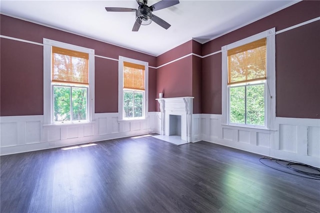 1703 Dauphin St, Mobile, AL 36604 - unfurnished living room with wainscoting, plenty of natural light, a ceiling fan, a fireplace, and wood finished floors