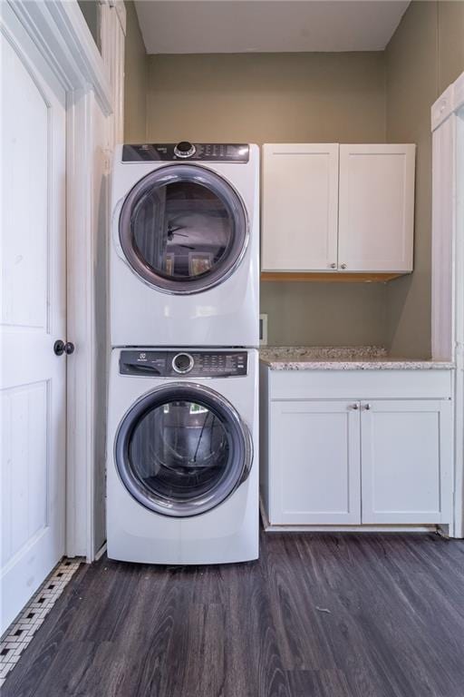 1703 Dauphin St, Mobile, AL 36604 - laundry room featuring stacked washer / dryer, cabinet space, and dark wood-type flooring