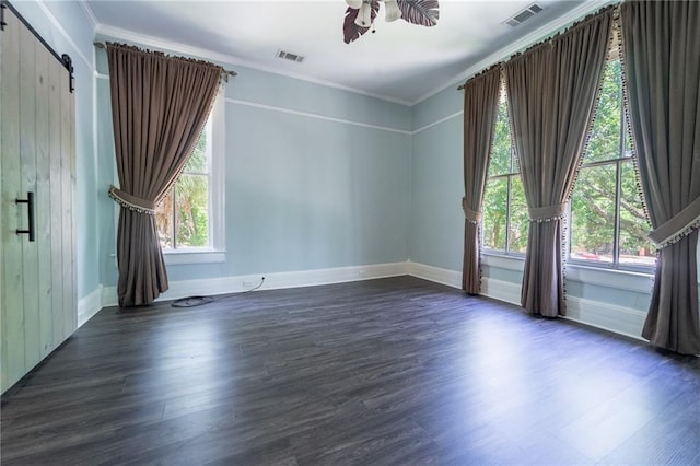 1703 Dauphin St, Mobile, AL 36604 - empty room featuring plenty of natural light, wood finished floors, a barn door, and ornamental molding