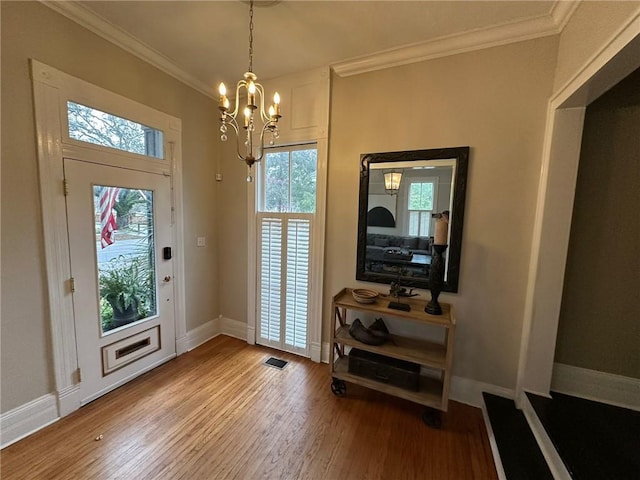 1703 Dauphin St, Mobile, AL 36604 - foyer entrance with wood finished floors, baseboards, a chandelier, and ornamental molding