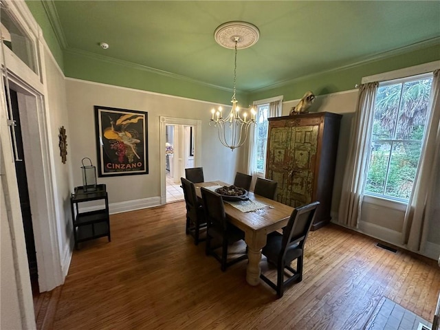 1703 Dauphin St, Mobile, AL 36604 - dining area featuring a chandelier, baseboards, hardwood / wood-style flooring, healthy amount of natural light, and ornamental molding