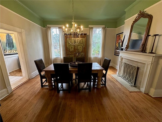 1703 Dauphin St, Mobile, AL 36604 - dining space featuring a chandelier, wood finished floors, baseboards, a fireplace, and crown molding