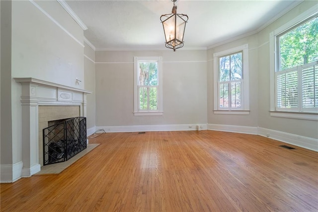 1703 Dauphin St, Mobile, AL 36604 - unfurnished living room featuring light wood finished floors, a fireplace with flush hearth, crown molding, baseboards, and a chandelier