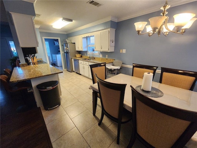 kitchen featuring sink, hanging light fixtures, stainless steel appliances, light stone counters, and white cabinets