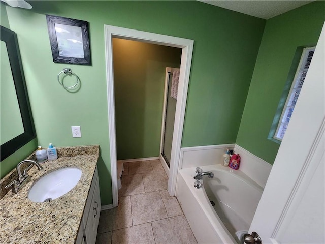 bathroom featuring toilet, vanity, a bath, and tile patterned flooring