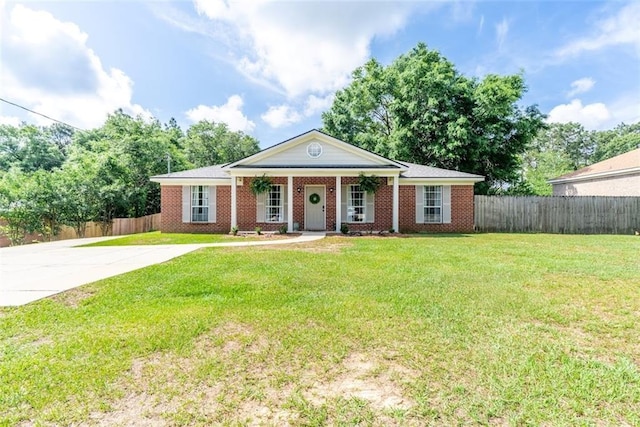 greek revival house featuring a porch, brick siding, fence, and a front yard