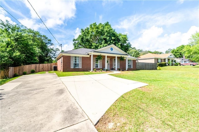 greek revival inspired property with fence, a porch, brick siding, and a front yard
