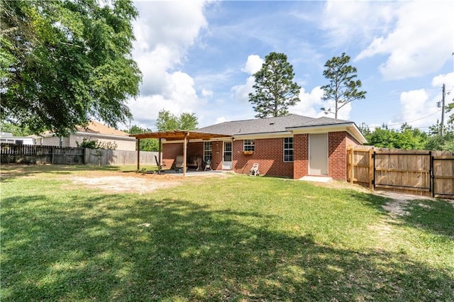 back of property with brick siding, a fenced backyard, a patio area, and a yard