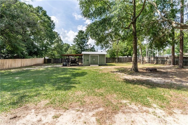 view of yard featuring a storage unit, a fenced backyard, and an outbuilding